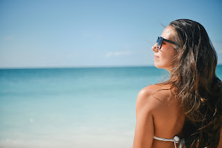 Sunglasses on girl at beach while wearing sunscreen